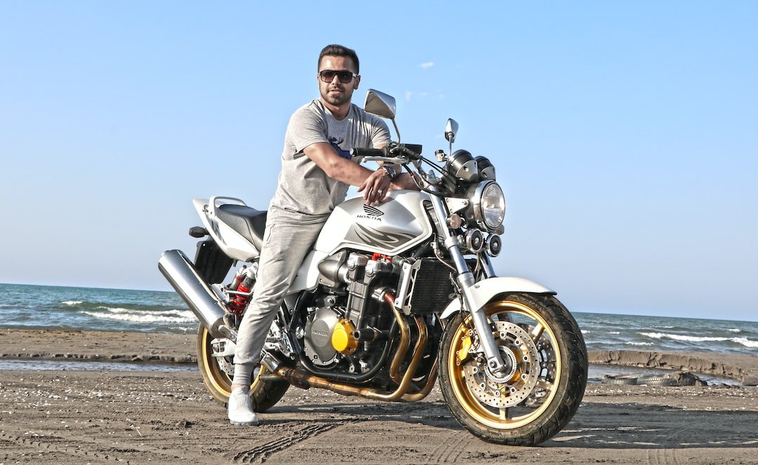 man riding on motorcycle on shoreline